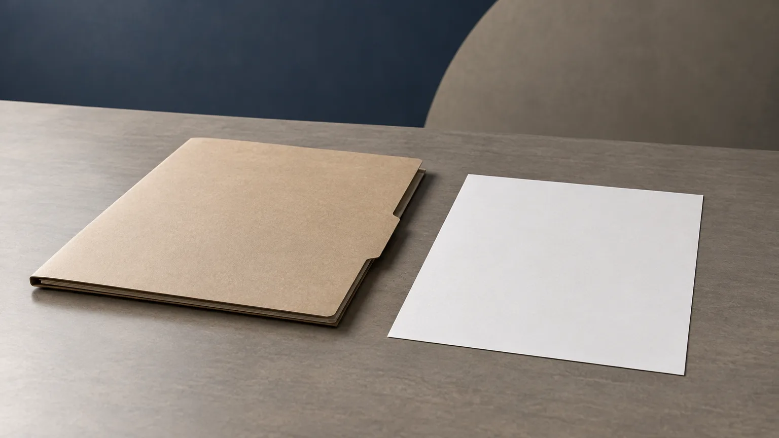 A plain closed folder and blank sheet on a desk.